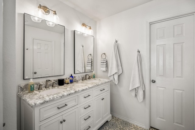 full bathroom with baseboards, a sink, and double vanity