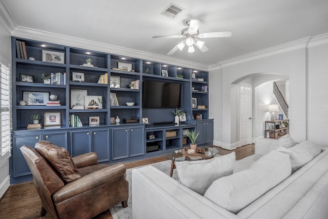 living area with crown molding, arched walkways, ceiling fan, and wood finished floors