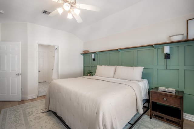 bedroom with ceiling fan, lofted ceiling, light wood-type flooring, and visible vents