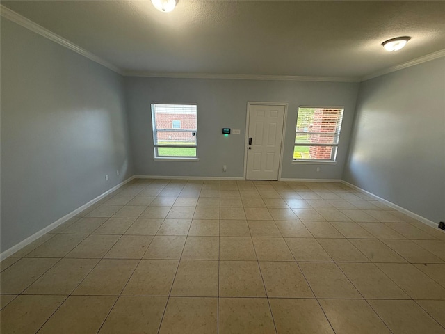 foyer featuring baseboards, a wealth of natural light, crown molding, and light tile patterned floors