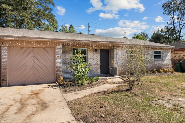 ranch-style home with concrete driveway, a front lawn, brick siding, and a garage