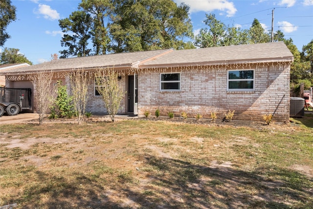 ranch-style house featuring a front lawn, brick siding, and central AC