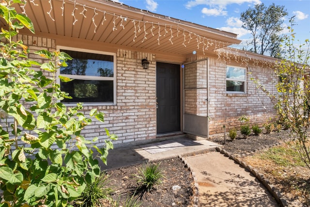 view of exterior entry with brick siding