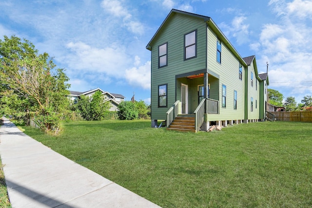 view of front of home with a front lawn and fence