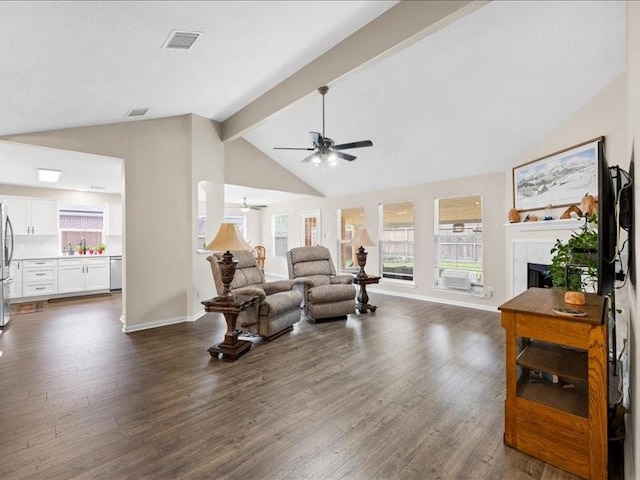 16339 Peach Orchard Dr, Humble, TX 77396 - living area with beam ceiling, dark wood-style flooring, a tiled fireplace, visible vents, and a ceiling fan