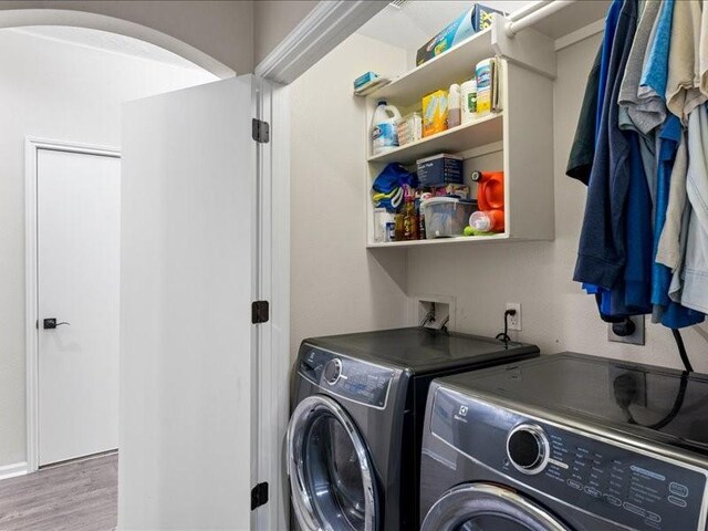 16339 Peach Orchard Dr, Humble, TX 77396 - laundry area with washing machine and dryer, wood finished floors, arched walkways, and laundry area