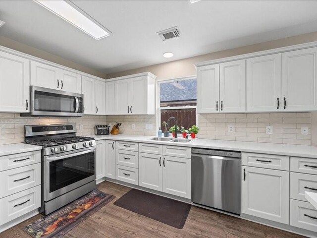 16339 Peach Orchard Dr, Humble, TX 77396 - kitchen featuring stainless steel appliances, a sink, visible vents, white cabinetry, and light countertops