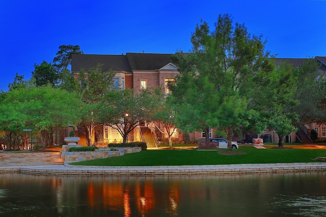 75 Colonial Row Dr, The Woodlands, TX 77380 - back of house featuring a lawn, stairway, and a water view