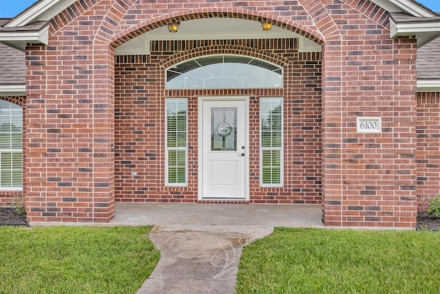 entrance to property featuring brick siding