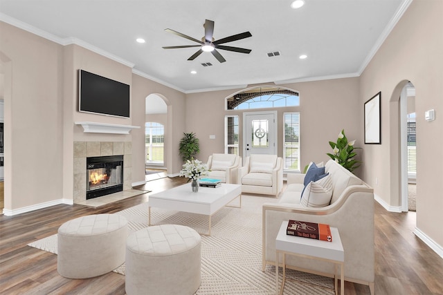 living room with wood finished floors, recessed lighting, and arched walkways