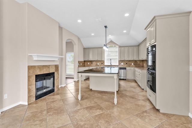 kitchen featuring a kitchen bar, tasteful backsplash, stainless steel dishwasher, dobule oven black, and lofted ceiling