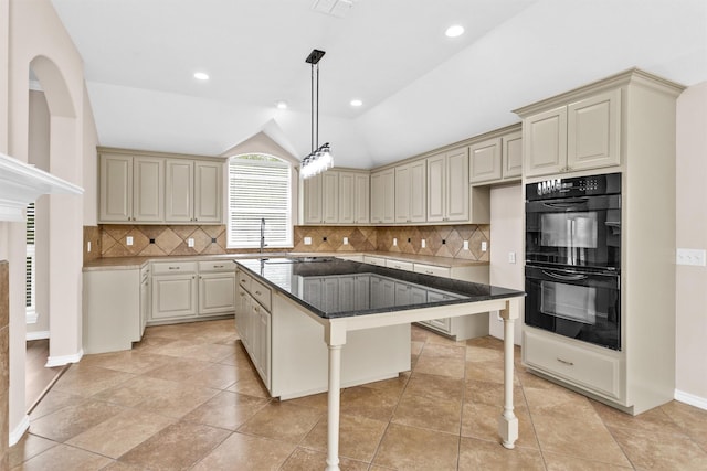 kitchen featuring cream cabinetry, dobule oven black, decorative backsplash, and a kitchen island