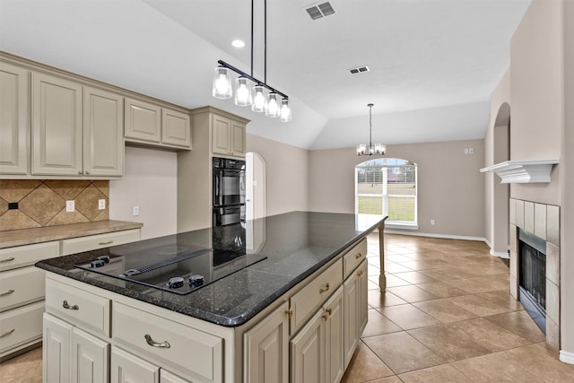 kitchen with black appliances, visible vents, cream cabinets, and backsplash