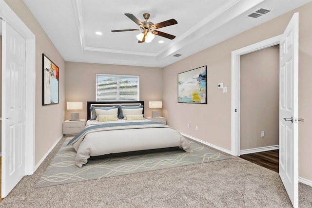 carpeted bedroom featuring recessed lighting, a raised ceiling, a ceiling fan, visible vents, and baseboards