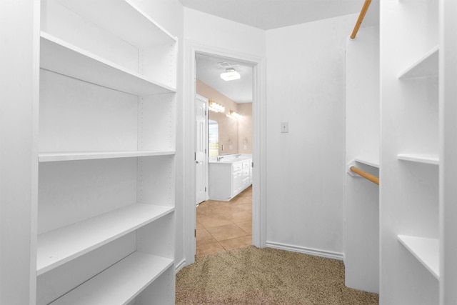 spacious closet featuring light tile patterned floors and light carpet