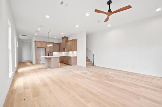 6703 Del Rio St, Houston, TX 77021 - kitchen featuring open floor plan, a kitchen island with sink, light countertops, recessed lighting, and light wood-type flooring