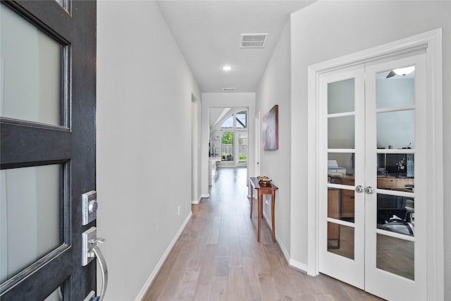 corridor with baseboards, french doors, visible vents, and light wood-style flooring