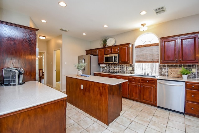 kitchen featuring light countertops, visible vents, a sink, tasteful backsplash, and appliances with stainless steel finishes