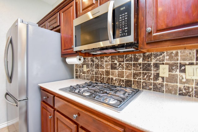 kitchen with stainless steel appliances, light countertops, and backsplash