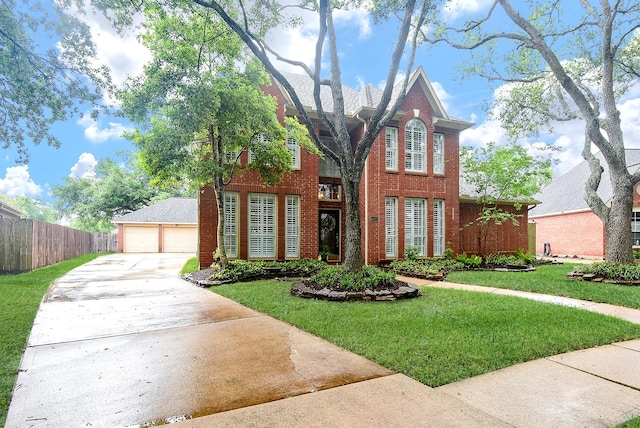 view of front of house with fence, a front lawn, brick siding, and a garage