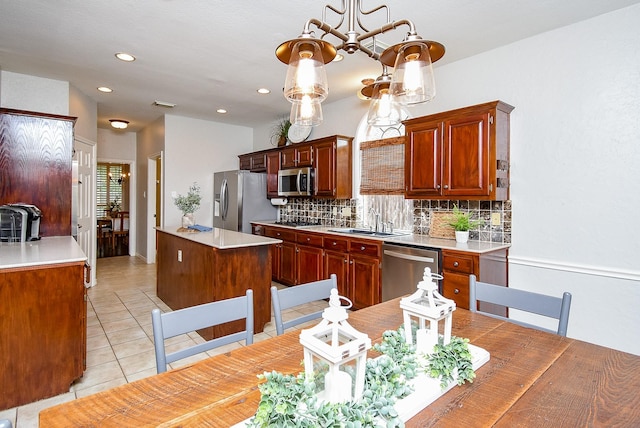 kitchen featuring stainless steel appliances, light tile patterned floors, a sink, a center island, and tasteful backsplash