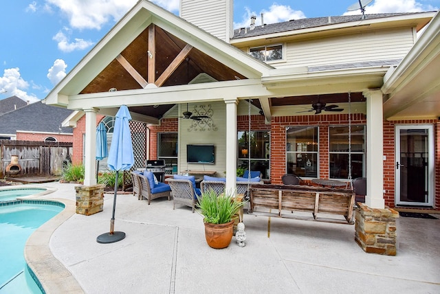 exterior space featuring fence, an outdoor hangout area, ceiling fan, a patio area, and a pool with connected hot tub