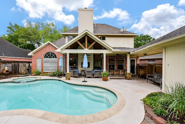 view of pool with a pool with connected hot tub, a patio, and fence