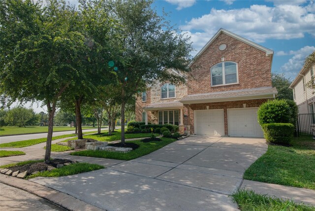 traditional home featuring a front lawn, brick siding, concrete driveway, an attached garage, and fence