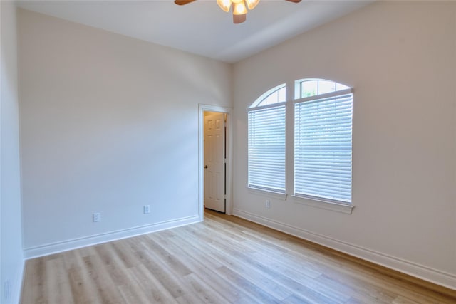 empty room featuring baseboards, wood finished floors, and a ceiling fan