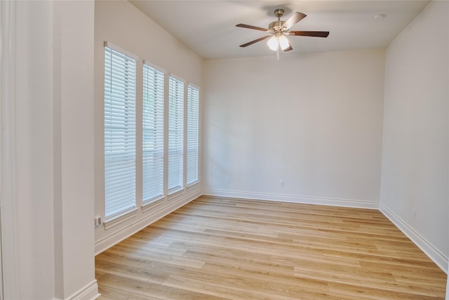 unfurnished room with baseboards, a ceiling fan, and light wood finished floors