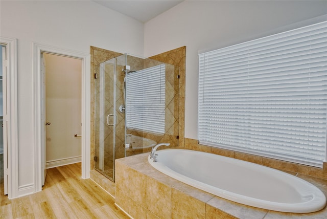 bathroom featuring wood finished floors, a shower stall, and a garden tub