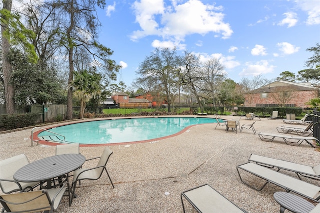 pool with fence and a patio