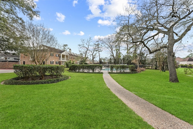 view of home's community featuring a pool, a yard, and a residential view