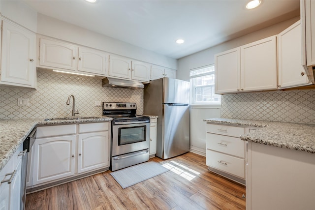 kitchen with white cabinetry, appliances with stainless steel finishes, under cabinet range hood, and a sink