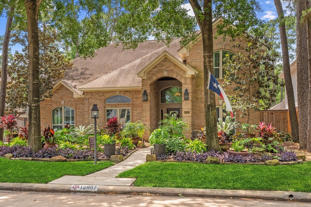 12907 Lake Mist Dr, Cypress, TX 77429 - view of front of home with fence, roof with shingles, a front yard, and brick siding