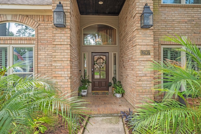 entrance to property featuring brick siding