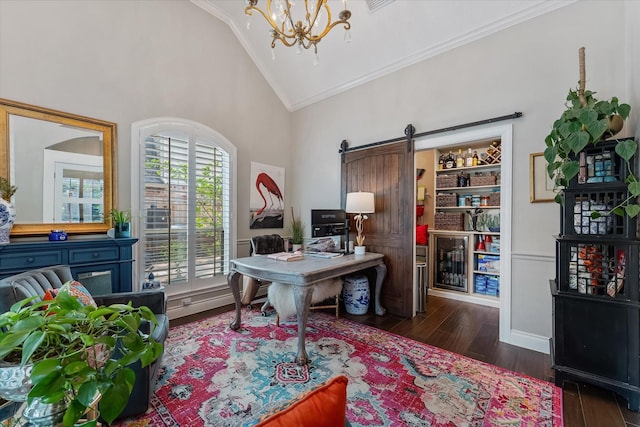 office area with wood finished floors, an inviting chandelier, a barn door, ornamental molding, and high vaulted ceiling