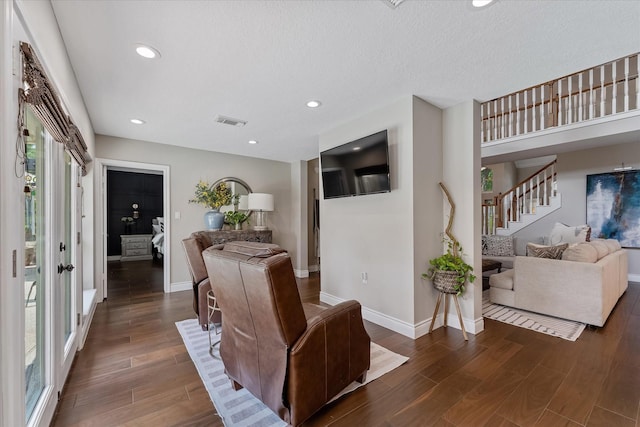 living area with baseboards, visible vents, and wood finished floors