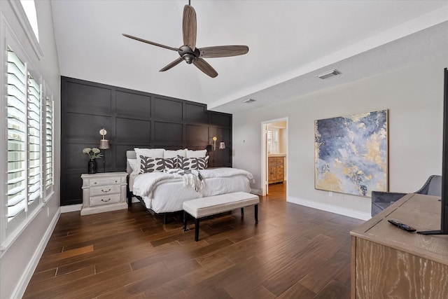 bedroom with dark wood-style floors, visible vents, multiple windows, and a decorative wall