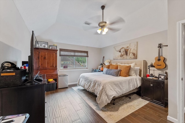 bedroom featuring baseboards, visible vents, wood finished floors, and a ceiling fan