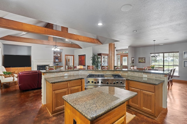 kitchen featuring a large island, high end stainless steel range, brown cabinetry, open floor plan, and ceiling fan with notable chandelier