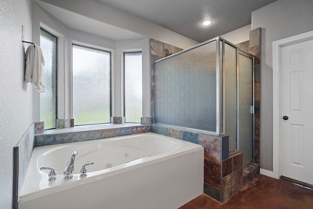 bathroom featuring a shower stall and a tub with jets