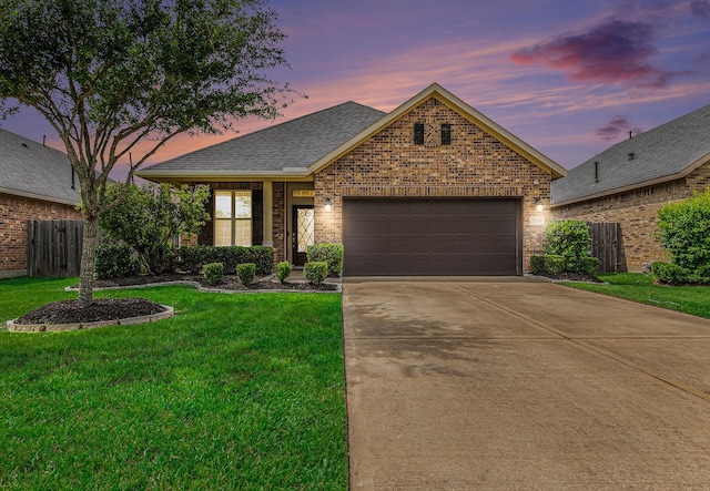 view of front facade featuring fence, a front lawn, brick siding, a garage, and driveway