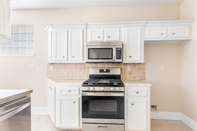 108 Harbour Town Cir, Conroe, TX 77356 - kitchen with decorative backsplash, stainless steel appliances, white cabinets, and light tile patterned floors