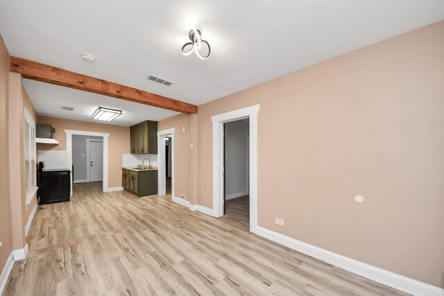 4415 Hershe St, Houston, TX 77020 - unfurnished living room featuring a sink, light wood-type flooring, baseboards, visible vents, and beamed ceiling
