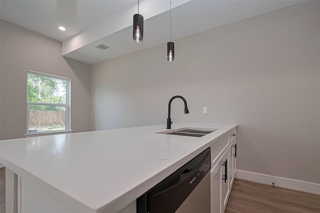 kitchen featuring wood finished floors, a sink, dishwasher, baseboards, and visible vents
