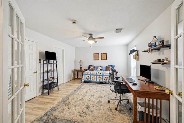 bedroom with visible vents, light wood finished floors, ceiling fan, and french doors