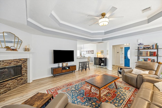 1807 Emerald Green Dr, Houston, TX 77094 - living room with a raised ceiling, ornamental molding, ceiling fan, light wood-style flooring, and a fireplace