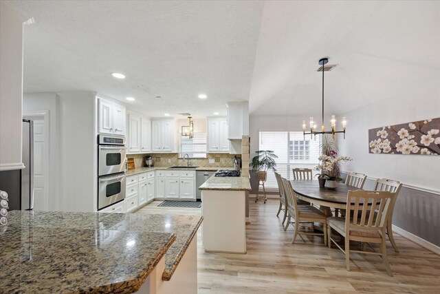 1807 Emerald Green Dr, Houston, TX 77094 - kitchen featuring a sink, appliances with stainless steel finishes, a chandelier, light wood-style floors, and white cabinets