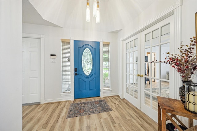 entryway featuring a chandelier, baseboards, french doors, and wood finished floors